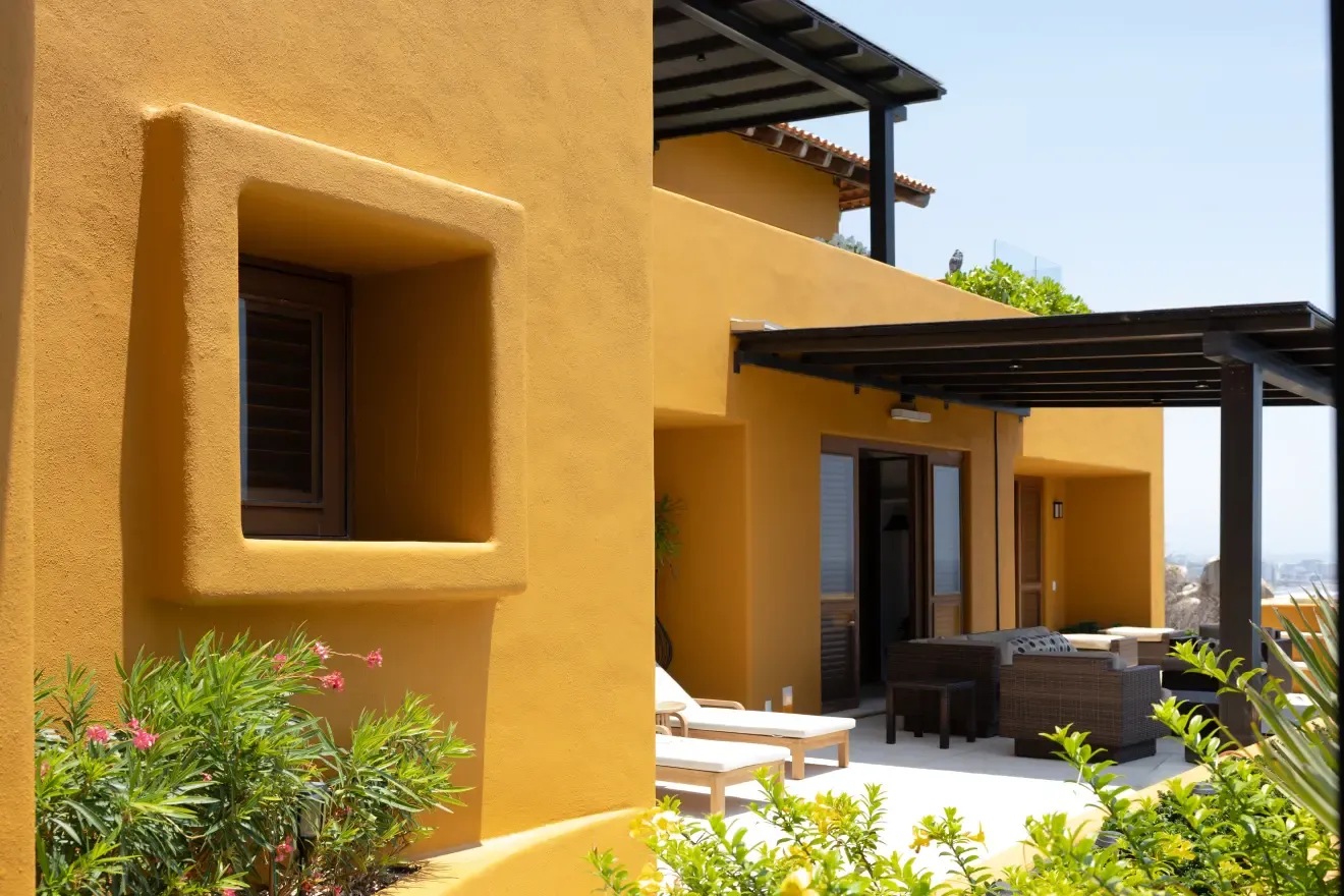 Fachada del departamento con su terraza y pérgola vistas desde el jardín